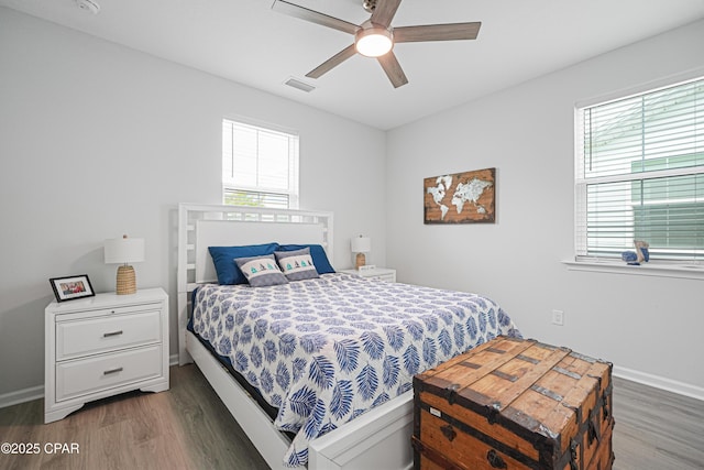 bedroom with visible vents, wood finished floors, and multiple windows