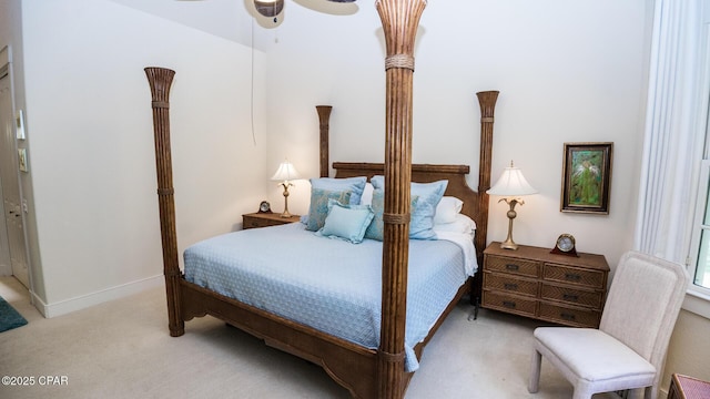 bedroom with a ceiling fan, baseboards, and light carpet