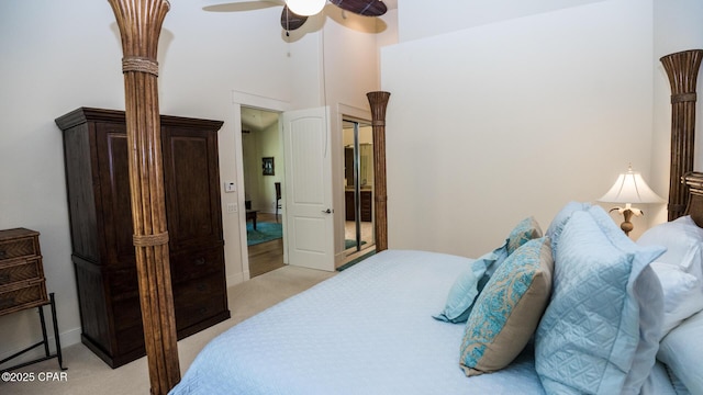 bedroom featuring light colored carpet, baseboards, ceiling fan, and a high ceiling