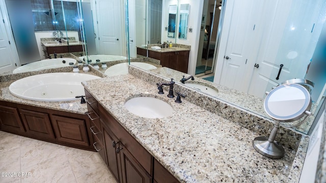 full bath with a whirlpool tub, a sink, two vanities, and a shower stall