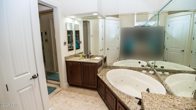 full bath with a jetted tub, vanity, and tile patterned floors