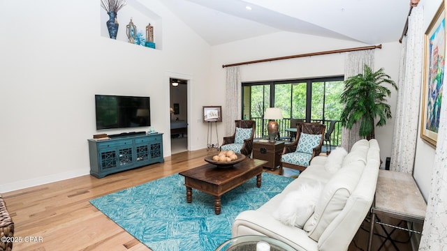 living room featuring baseboards, wood finished floors, and high vaulted ceiling