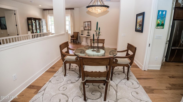dining space featuring baseboards and light wood-style flooring