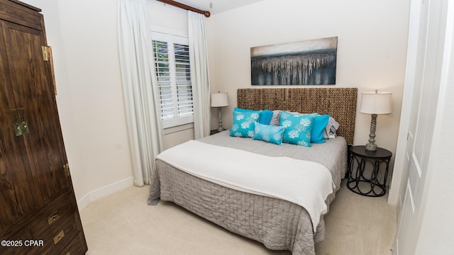 bedroom with baseboards and light carpet