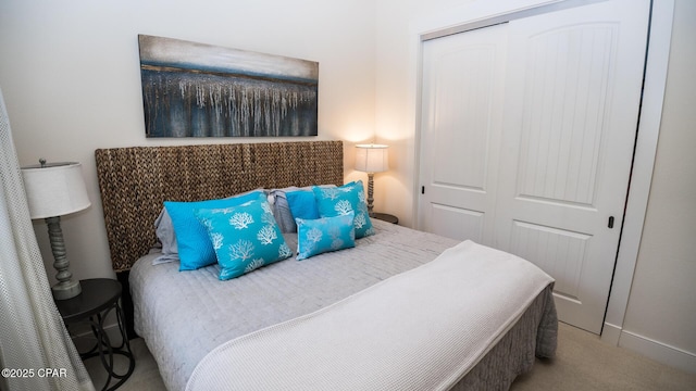 carpeted bedroom with baseboards and a closet