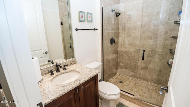 bathroom featuring vanity, toilet, and a shower stall