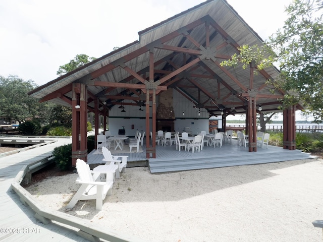 view of community featuring a gazebo, a wooden deck, and outdoor dining area
