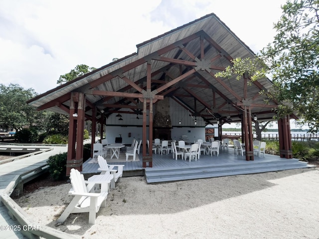 surrounding community featuring outdoor dining area, a wooden deck, and a gazebo