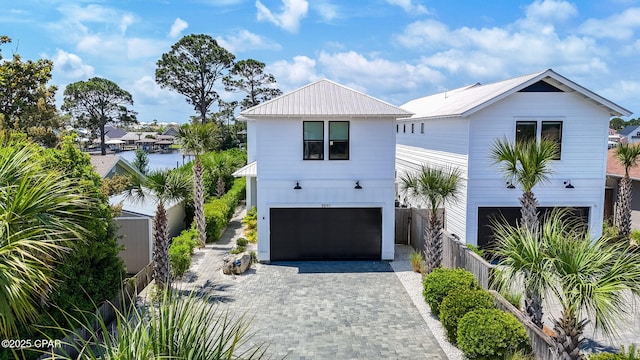 8597 N Lagoon Dr, Panama City, FL 32408 - view of front of home featuring an attached garage, decorative driveway, and fence