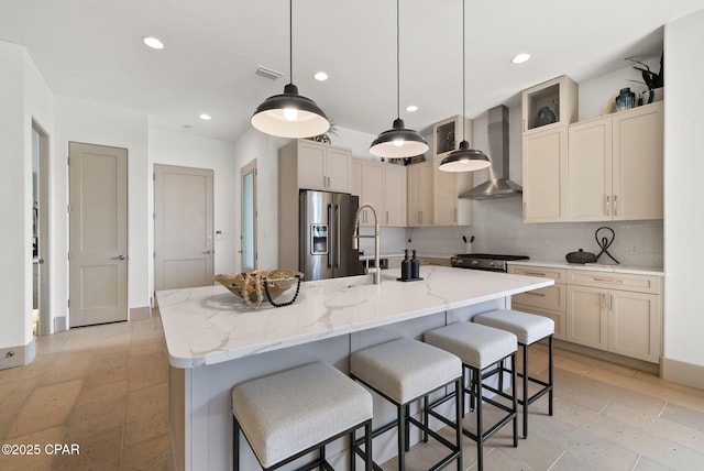 8597 N Lagoon Dr, Panama City, FL 32408 - kitchen featuring high quality fridge, visible vents, a kitchen bar, backsplash, and wall chimney range hood