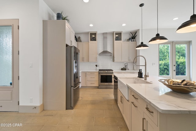 8597 N Lagoon Dr, Panama City, FL 32408 - kitchen with appliances with stainless steel finishes, a sink, wall chimney exhaust hood, tasteful backsplash, and a large island with sink