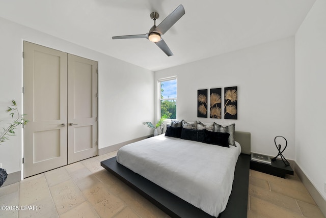 8597 N Lagoon Dr, Panama City, FL 32408 - bedroom with ceiling fan, baseboards, and stone tile flooring