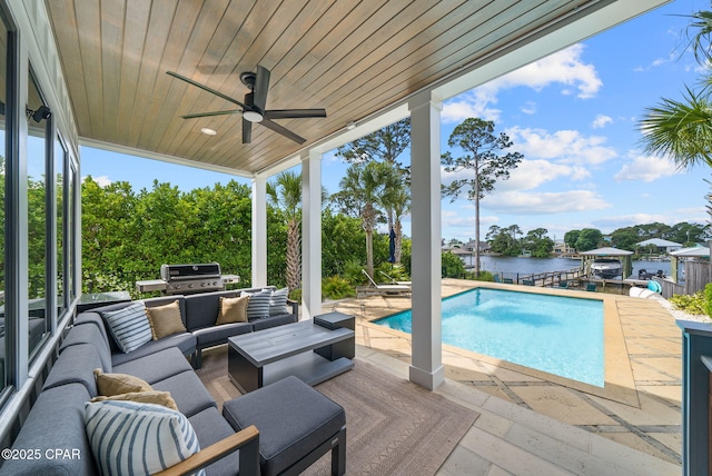 8597 N Lagoon Dr, Panama City, FL 32408 - outdoor pool with a patio, outdoor lounge area, a ceiling fan, a water view, and an outdoor kitchen