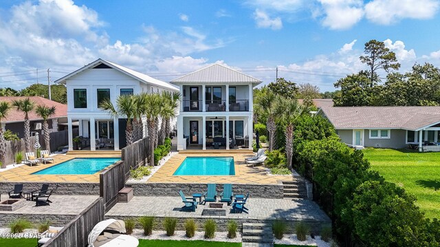 8597 N Lagoon Dr, Panama City, FL 32408 - rear view of property featuring a balcony, a patio area, a fenced in pool, and a fenced backyard