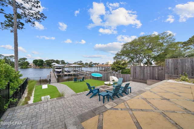 8597 N Lagoon Dr, Panama City, FL 32408 - view of patio with fence, a water view, boat lift, and a dock