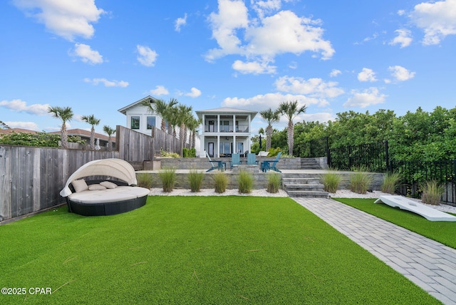 8597 N Lagoon Dr, Panama City, FL 32408 - view of yard featuring a balcony, a patio, and a fenced backyard