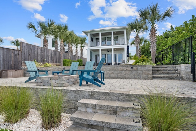 8597 N Lagoon Dr, Panama City, FL 32408 - exterior space featuring a balcony, a patio, a fenced backyard, a ceiling fan, and an outdoor fire pit