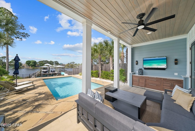 8597 N Lagoon Dr, Panama City, FL 32408 - view of patio / terrace with a water view, a fenced in pool, ceiling fan, and a fenced backyard