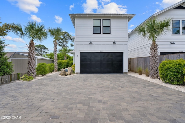 8597 N Lagoon Dr, Panama City, FL 32408 - view of side of property with a garage, fence, and decorative driveway