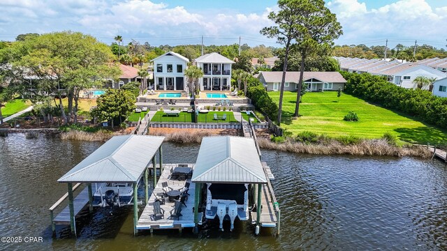 8597 N Lagoon Dr, Panama City, FL 32408 - dock area with a water view, an outdoor pool, a lawn, and boat lift