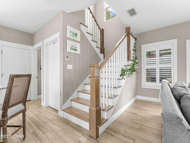 stairway featuring visible vents, wood finished floors, and baseboards
