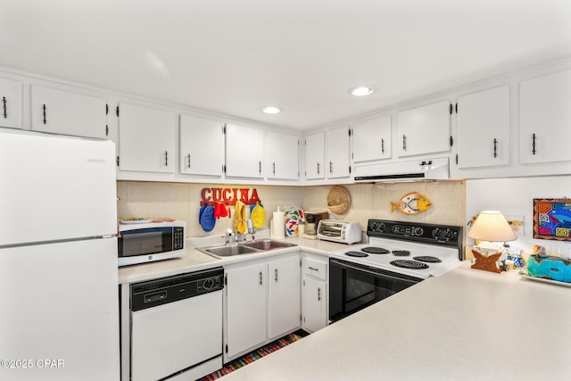 kitchen with a sink, white cabinets, under cabinet range hood, and white appliances