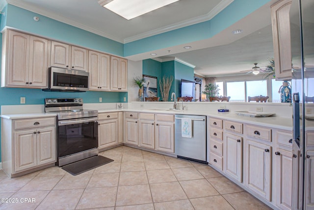 8601 Surf Dr Unit 14E, Panama City, FL 32408 - kitchen featuring appliances with stainless steel finishes, a sink, light countertops, a ceiling fan, and ornamental molding