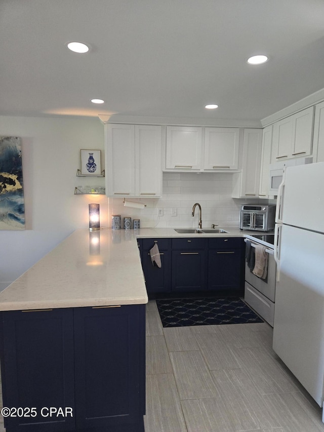 4725 Bay Point Rd Unit 262, Panama City Beach, FL 32408 - kitchen with a sink, a peninsula, white appliances, and white cabinetry