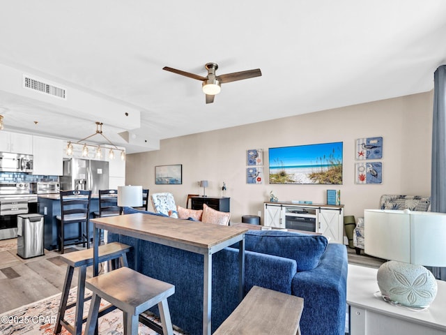 9860 S Thomas Dr Unit 1202, Panama City Beach, FL 32408 - living area featuring a ceiling fan and light wood-style flooring