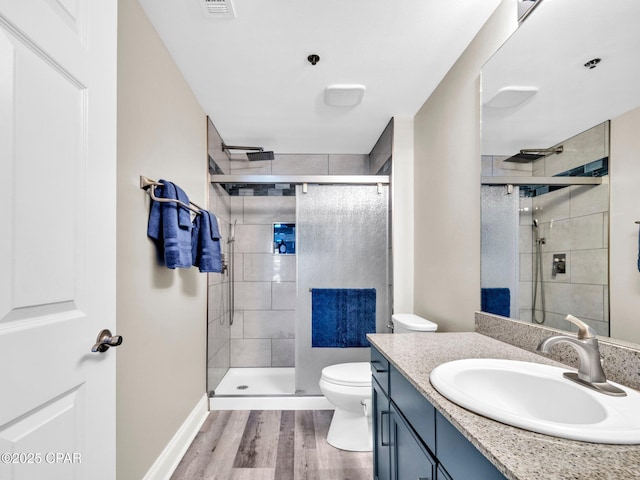 9860 S Thomas Dr Unit 1202, Panama City Beach, FL 32408 - bathroom featuring wood finished floors, a shower stall, toilet, vanity, and baseboards