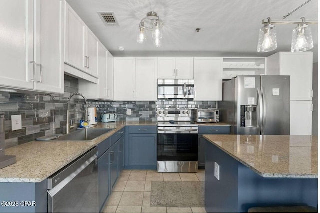 9860 S Thomas Dr Unit 1202, Panama City Beach, FL 32408 - kitchen with stainless steel appliances, a sink, tasteful backsplash, light tile patterned flooring, and white cabinets