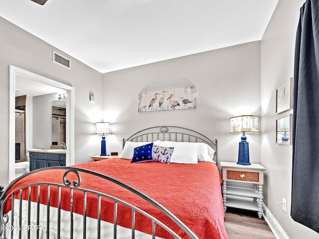 9860 S Thomas Dr Unit 1202, Panama City Beach, FL 32408 - bedroom with a sink, wood finished floors, ensuite bathroom, and baseboards