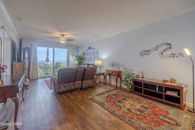 living area featuring crown molding, wood-type flooring, and a ceiling fan