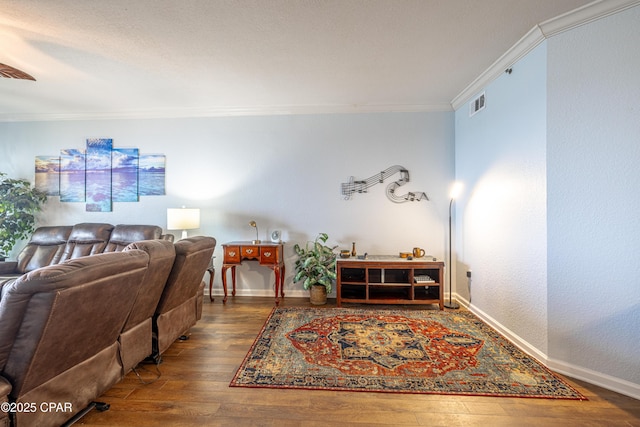 living area with crown molding, hardwood / wood-style floors, and baseboards