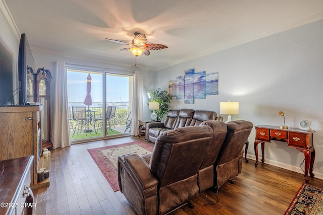 living room featuring crown molding, ceiling fan, hardwood / wood-style flooring, and baseboards