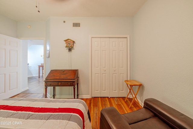 bedroom with wood finished floors and a closet
