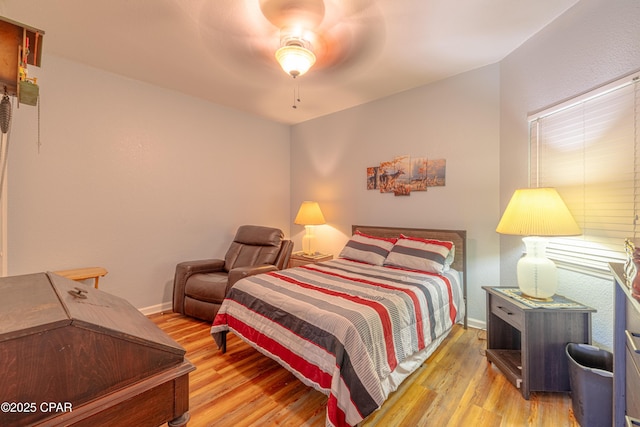 bedroom with wood finished floors, baseboards, and a ceiling fan