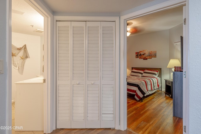 bedroom with wood finished floors and a closet