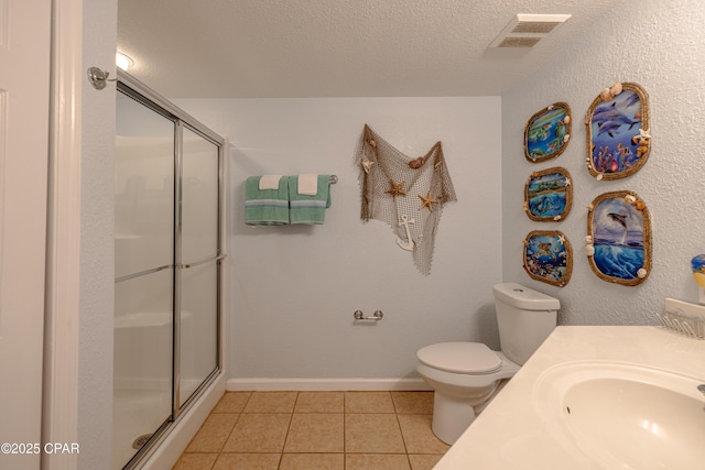 full bathroom featuring tile patterned floors, a shower stall, toilet, a textured ceiling, and vanity