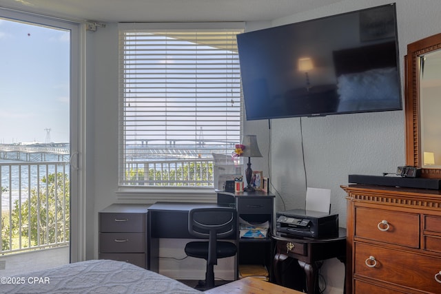 bedroom featuring a desk and a water view