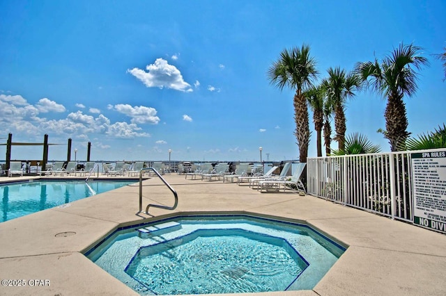 community pool featuring a community hot tub, a patio area, and fence