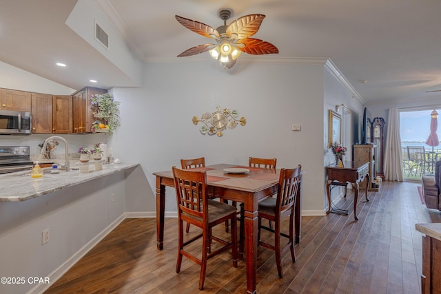 dining space featuring ornamental molding, dark wood-type flooring, ceiling fan, baseboards, and recessed lighting