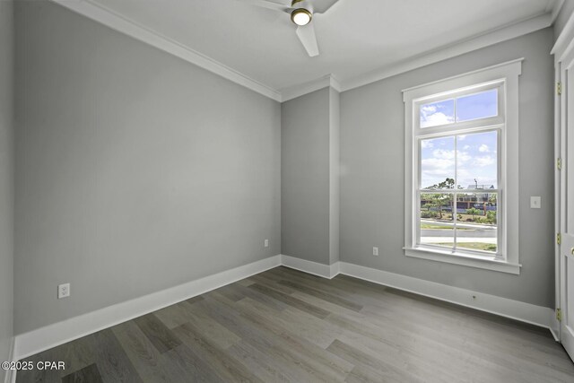 empty room with crown molding, ceiling fan, baseboards, and wood finished floors