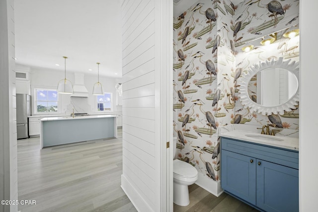 full bathroom featuring vanity, toilet, recessed lighting, wallpapered walls, and wood finished floors