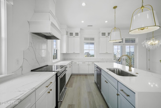kitchen with a sink, white cabinets, stainless steel appliances, recessed lighting, and an island with sink