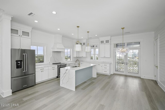 kitchen with stainless steel appliances, a wealth of natural light, a sink, and custom range hood