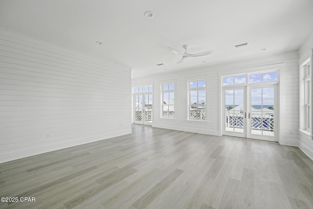 interior space with ceiling fan, visible vents, a wealth of natural light, and wood finished floors