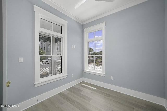 unfurnished room featuring crown molding, baseboards, ceiling fan, and wood finished floors