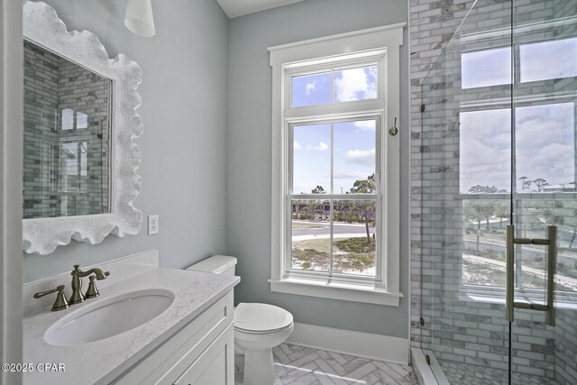 bathroom with plenty of natural light, a shower stall, toilet, and vanity