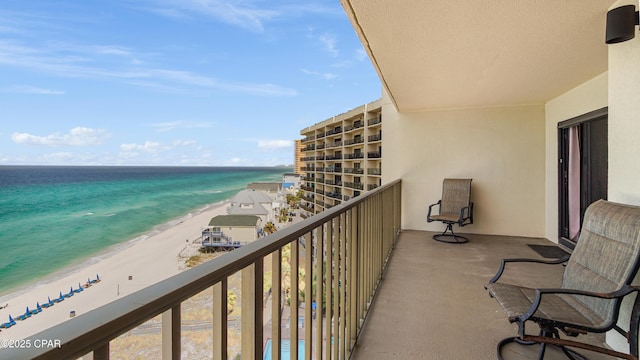 balcony featuring a water view and a view of the beach